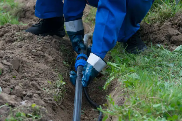 A person in blue and white working on a hole.