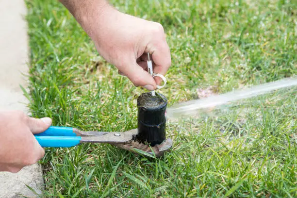 A person is using a pair of scissors to cut the hose.