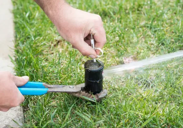 A person is using a pair of scissors to cut the hose.